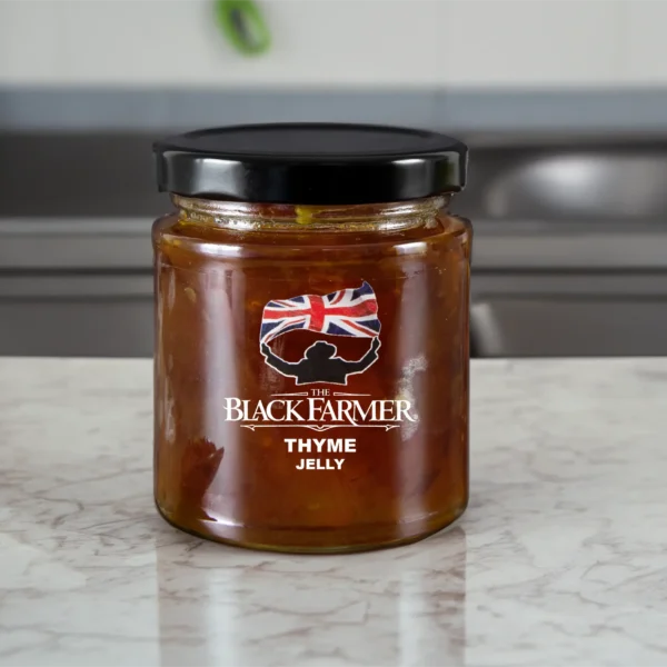 A jar of The Black Farmer’s Thyme Jelly, displaying a green-tinted jelly with thyme sprigs on the label.